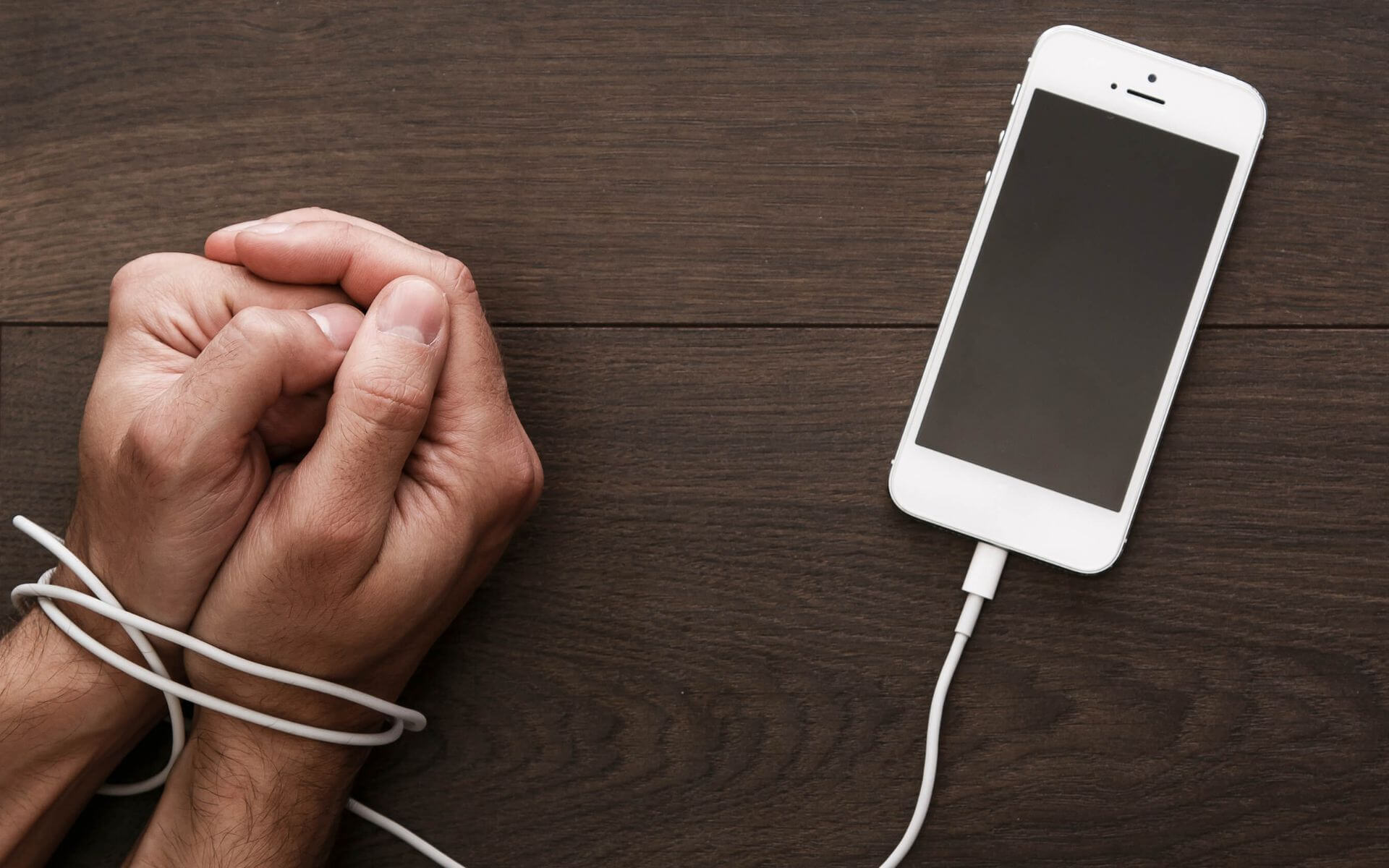 mobil zsinórjával megkötözött kéz